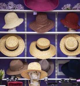 A stylish assortment of summer hats on shelves, featured in a fashionable store display.
