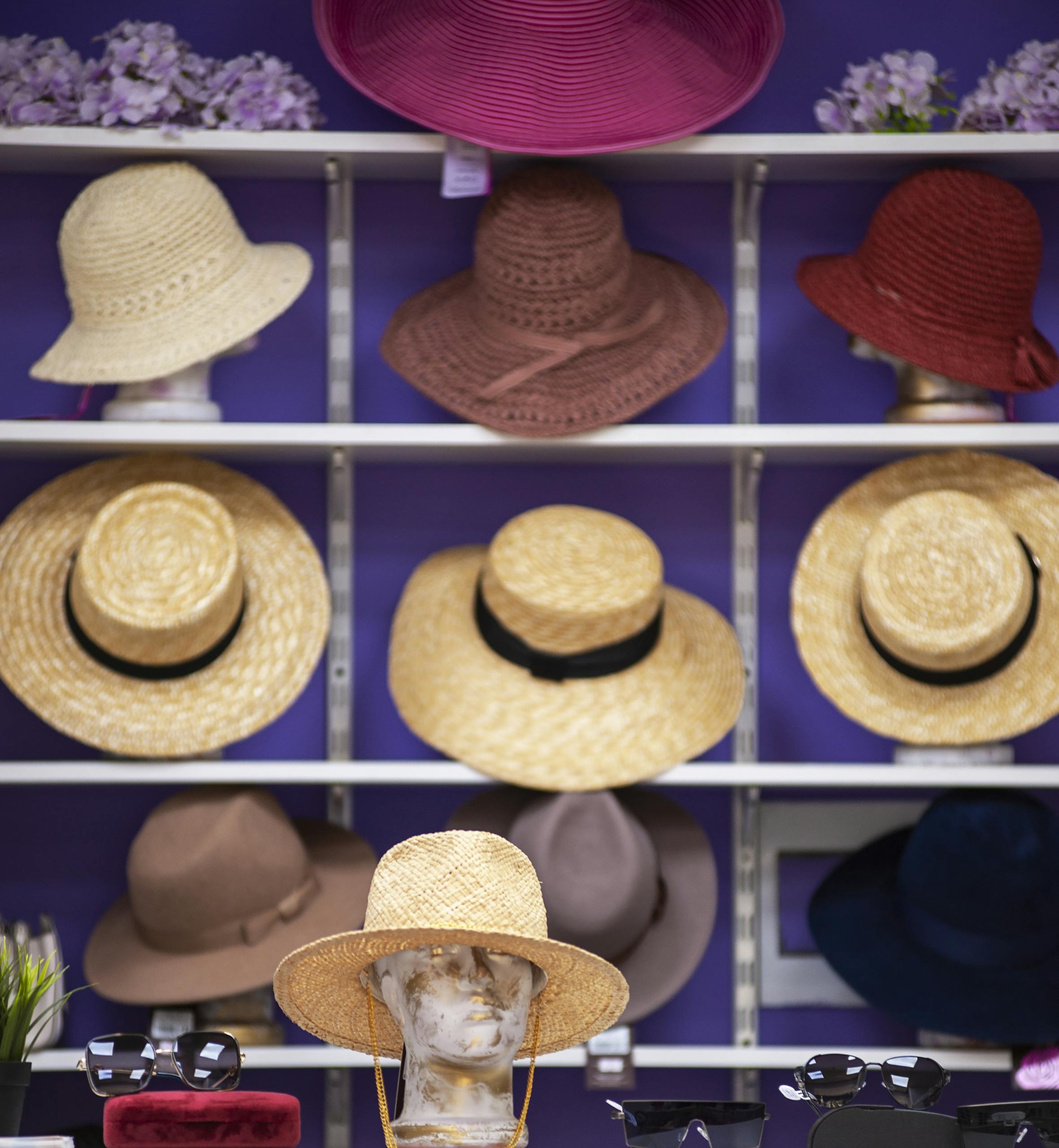 A stylish assortment of summer hats on shelves, featured in a fashionable store display.