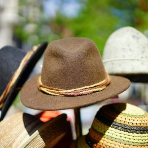 A vibrant display of fashionable fedoras stacked outdoors. Perfect for sun protection and style.