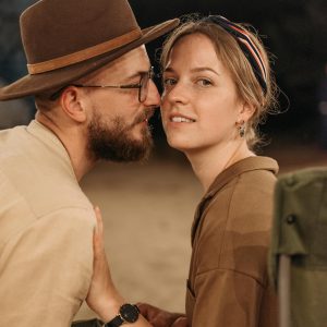 A couple sharing a romantic moment outdoors under string lights, perfect for travel or lifestyle themes.